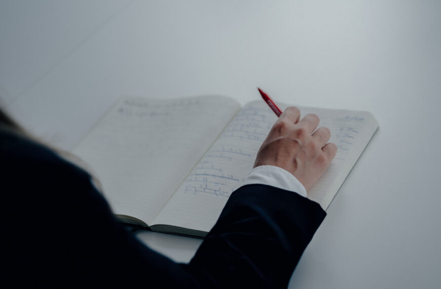 En advokat med en penn i hånden og en notisblokk på bordet