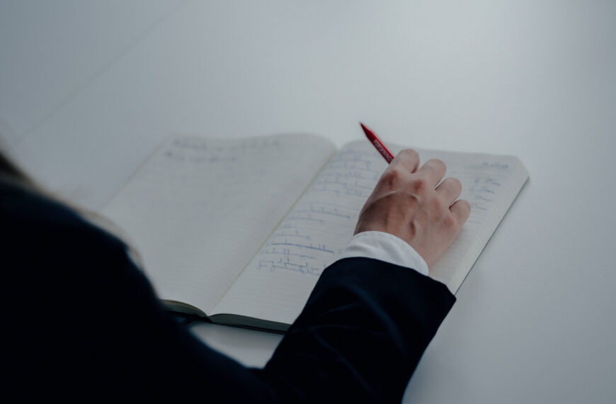 A lawyer with a pen in hand and a notepad on the table